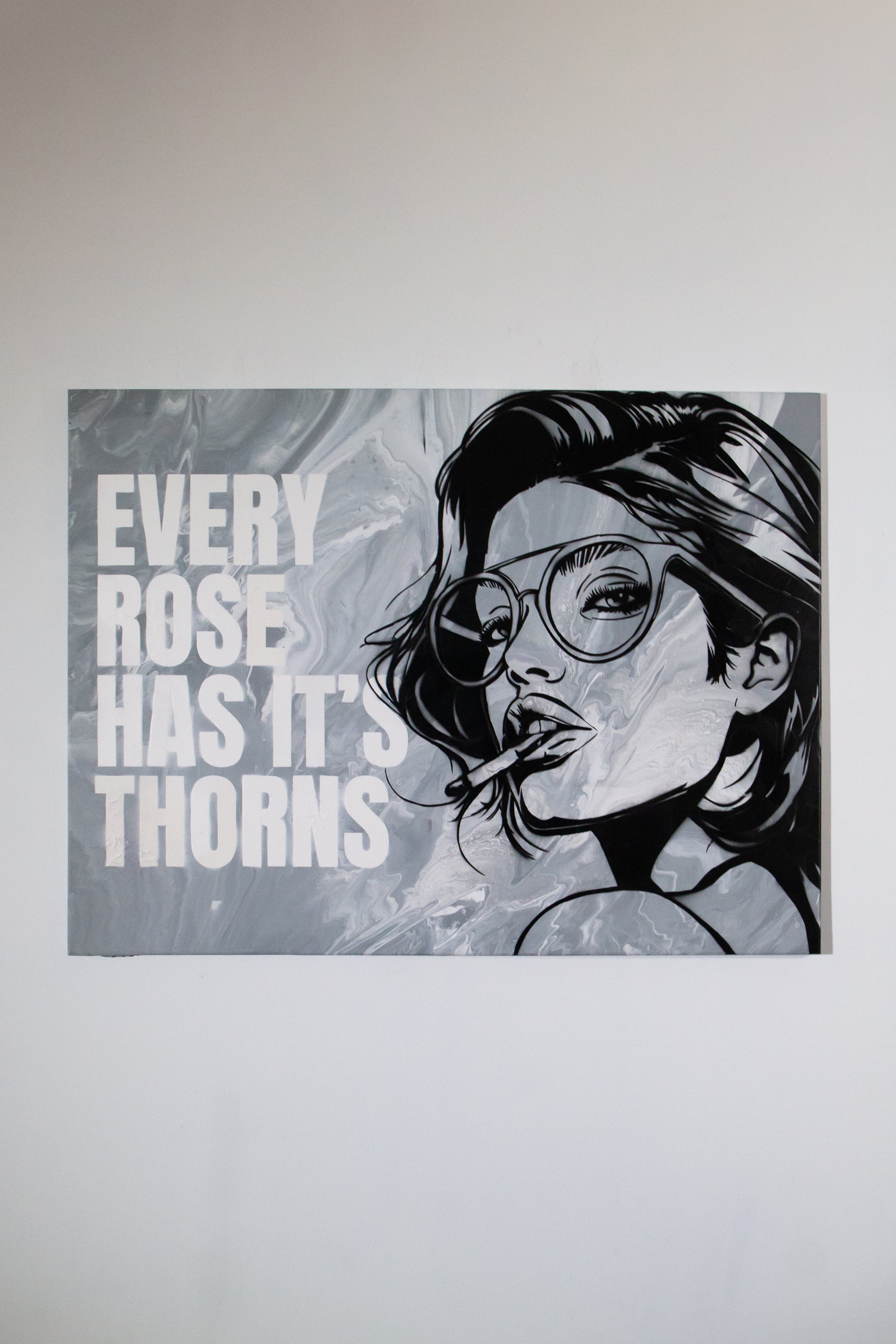 Black and white illustration of a woman with glasses and text Every rose has its thorns' on a gray background made with stencils